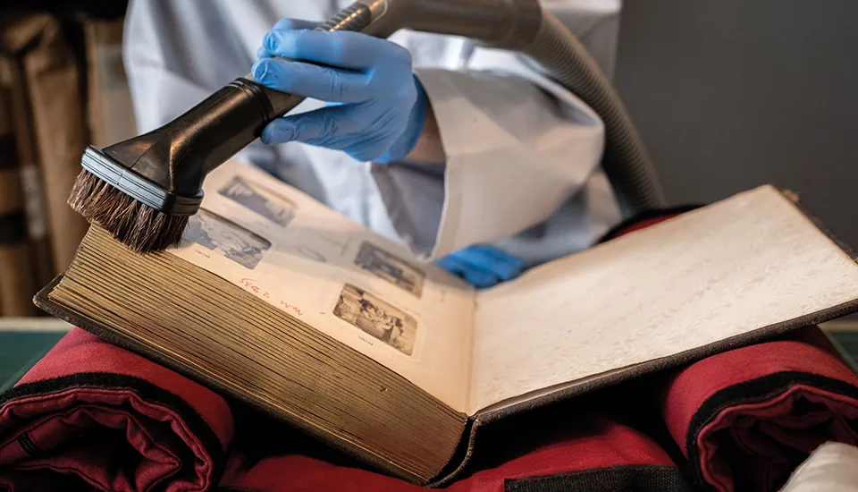Aspiration des poussière sur un livre ancien protégé sur tissus pour ne pas casser la couverture